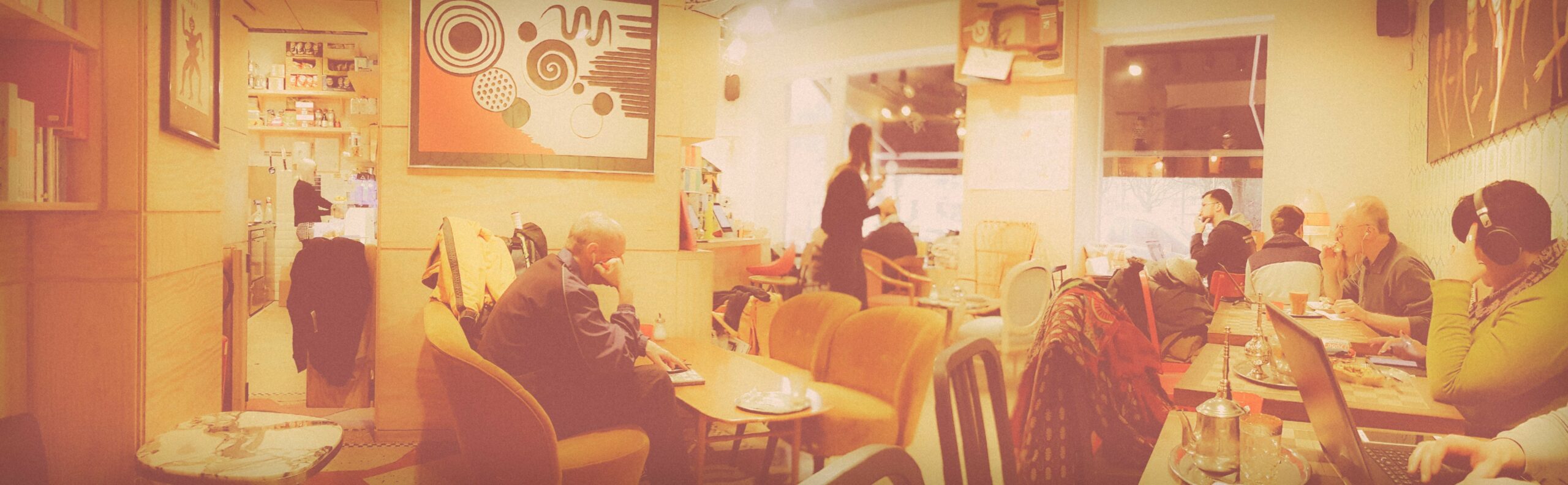 vue intérieure d'un café, tables fauteuils et personnes